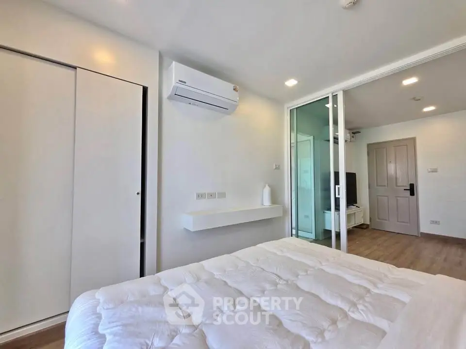 Modern bedroom with air conditioning and sliding glass doors in a stylish apartment.