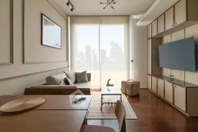 Modern living room with city view, featuring sleek furniture and large TV, perfect for urban living.