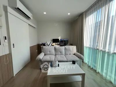 Modern living room with large windows and cozy sofa in bright apartment