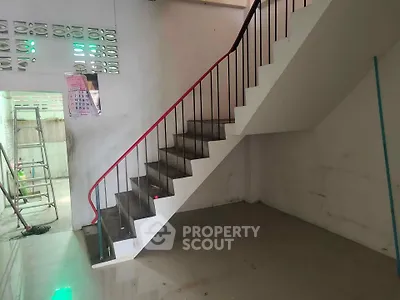 Spacious interior with modern staircase and tiled flooring, ideal for renovation or customization.