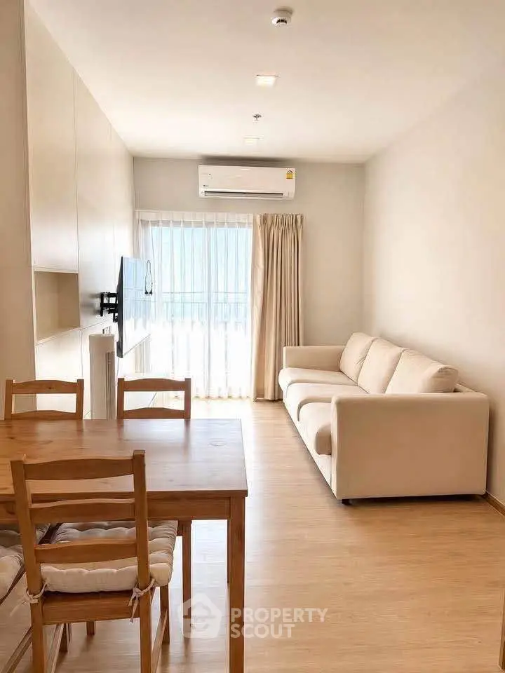 Modern living room with natural light, cozy sofa, and dining area in a stylish apartment.