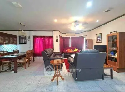 Spacious living room with elegant leather sofas and dining area, perfect for family gatherings.