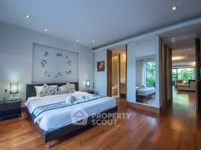 Luxurious bedroom with elegant decor and hardwood floors in a modern home.