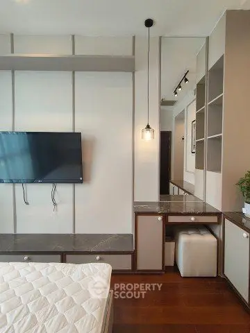 Modern bedroom with wall-mounted TV and stylish decor