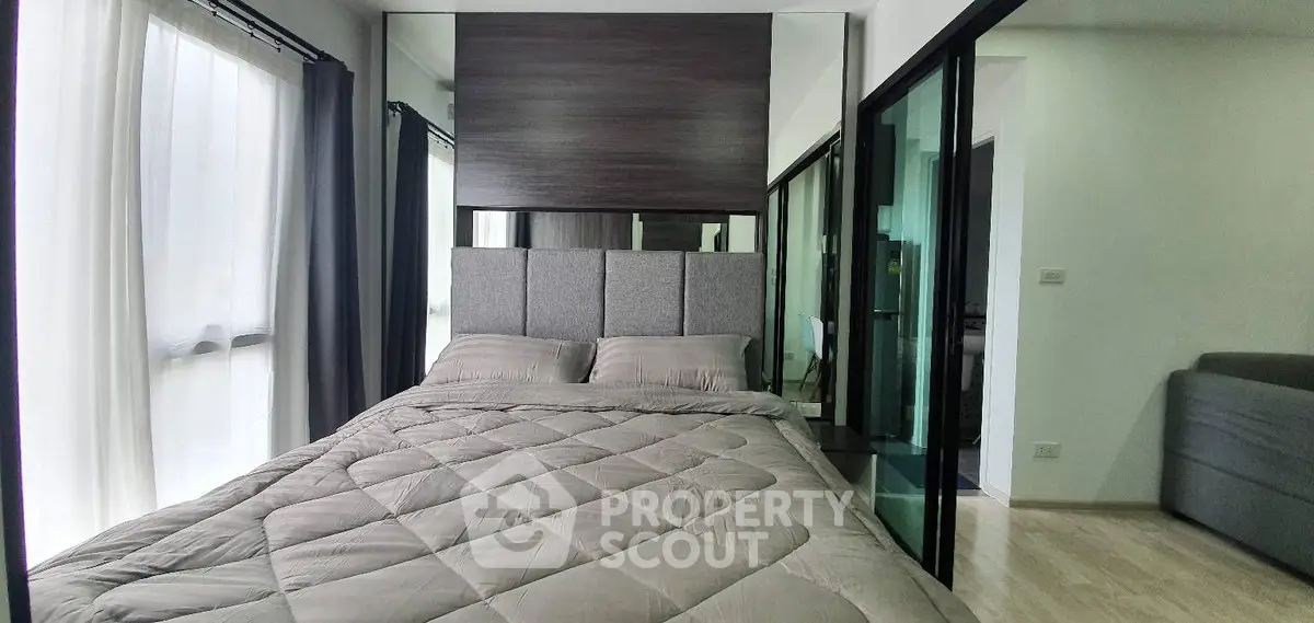 Modern bedroom with stylish decor and large windows for natural light.