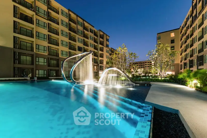 Luxurious apartment complex with stunning pool and modern architecture at night.
