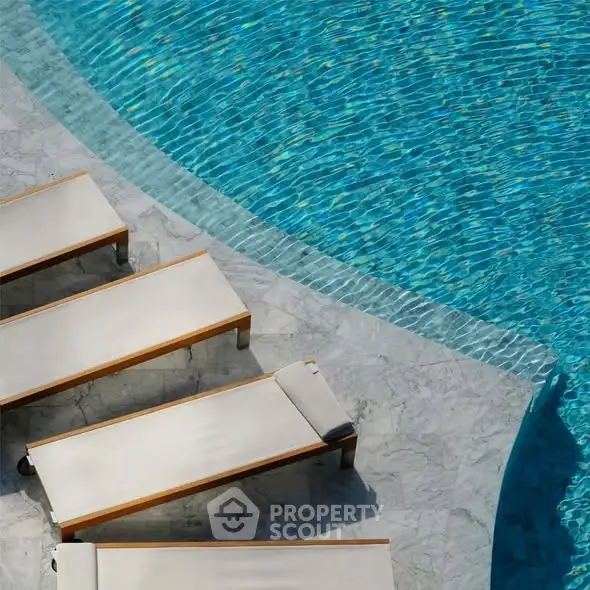 Luxurious poolside with elegant sun loungers and shimmering blue water