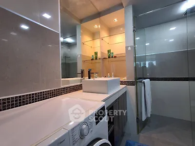 Modern bathroom with washing machine and glass shower enclosure