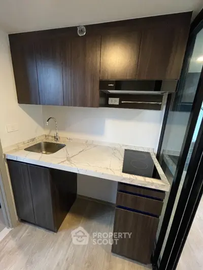 Modern compact kitchen with marble countertop and sleek cabinetry