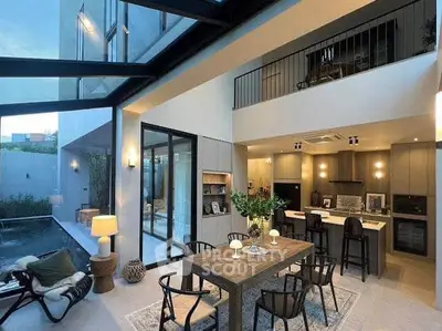 Stunning modern open-plan living area with high ceilings and pool view, perfect for luxury living.