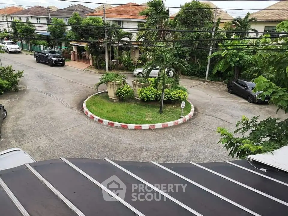 Charming residential neighborhood with lush greenery and roundabout view.