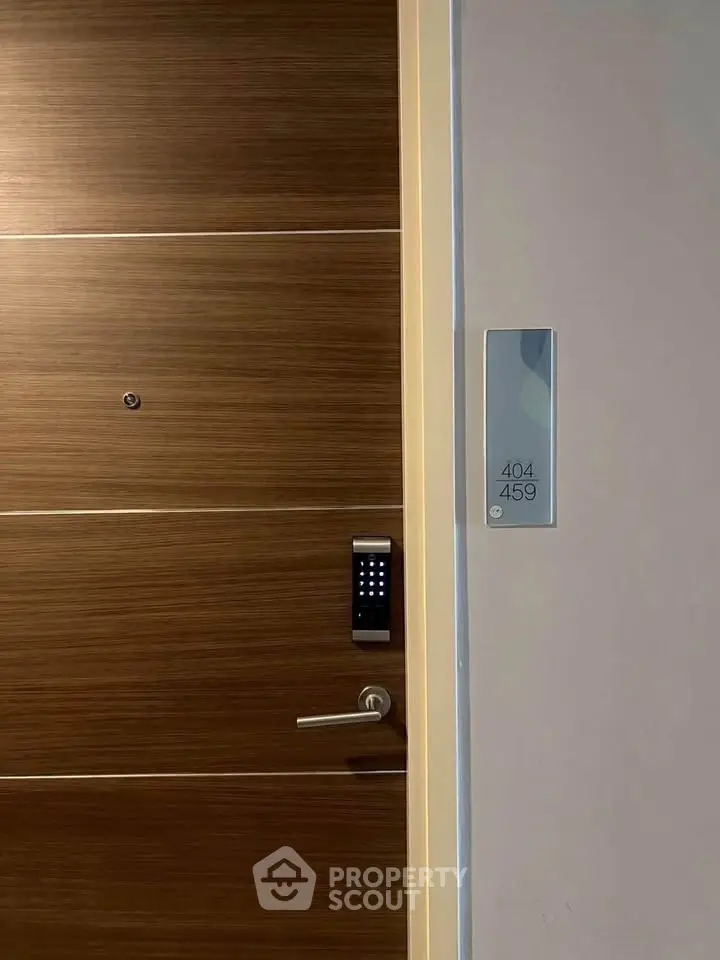 Modern apartment door with digital lock and room number signage.
