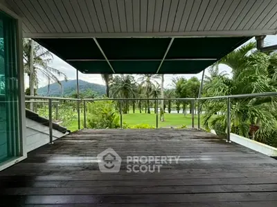 Spacious balcony with stunning green view and palm trees, perfect for relaxation.