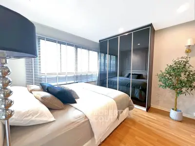 Modern bedroom with large mirrored wardrobe and stylish decor