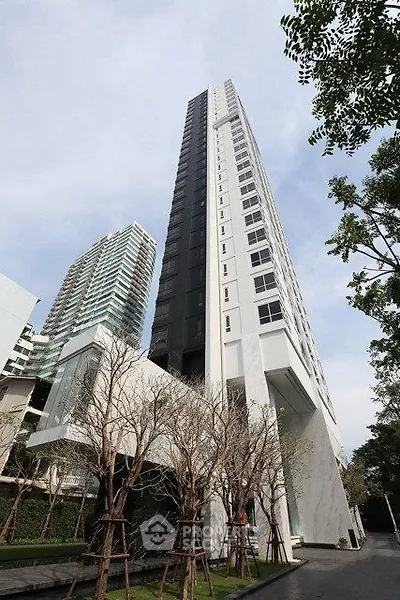 Stunning modern high-rise building with sleek architecture and lush surroundings.