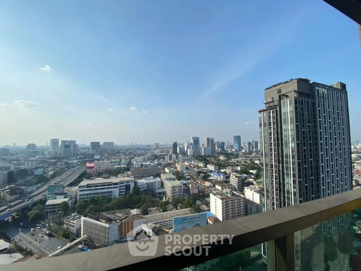 Stunning cityscape view from high-rise balcony with clear blue sky