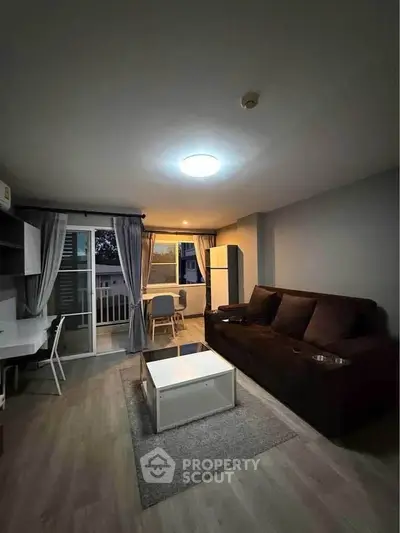 Modern living room with cozy sofa, stylish decor, and balcony access in a contemporary apartment.