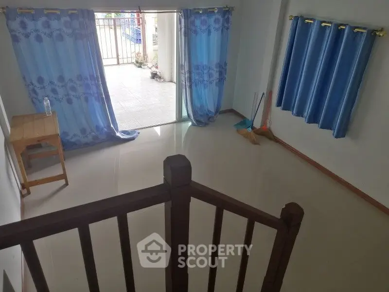Spacious living room with open balcony and blue curtains