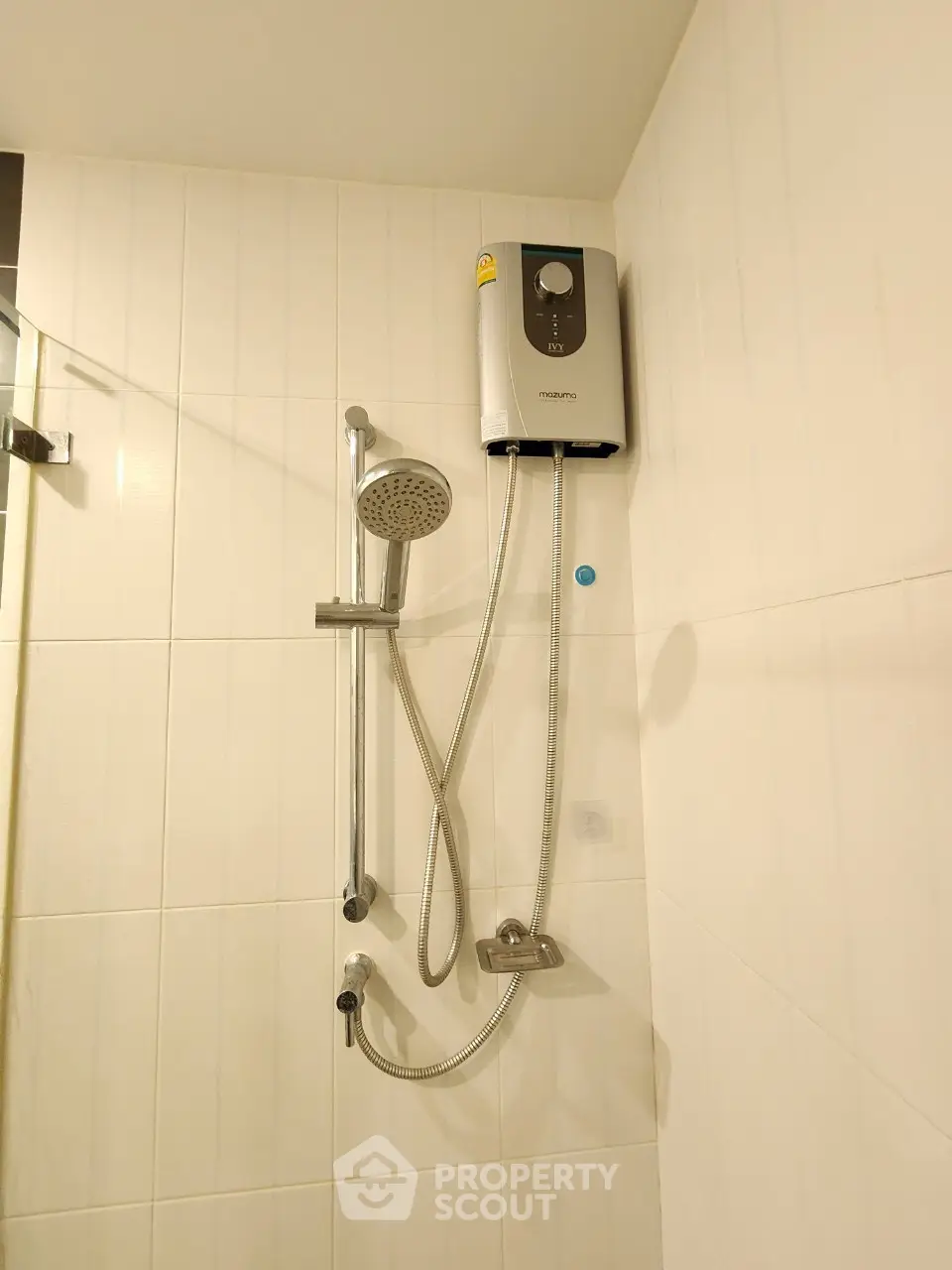 Modern bathroom with sleek showerhead and water heater on tiled wall.