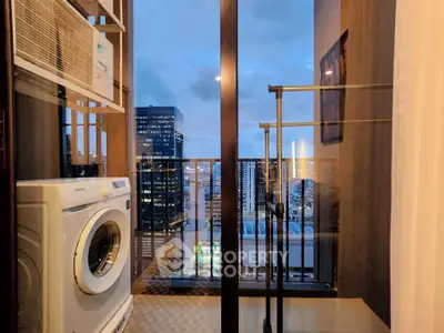 Modern apartment balcony with washing machine and city view at dusk
