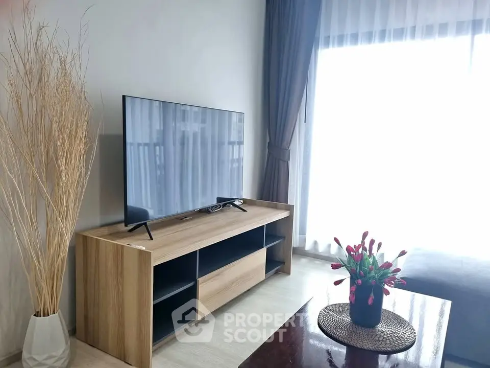 Modern living room with sleek TV stand and large window for natural light.