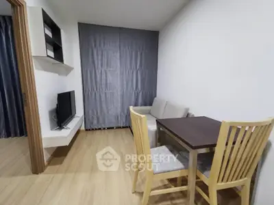 Modern living room with cozy seating and dining area, featuring sleek wooden flooring and minimalist decor.