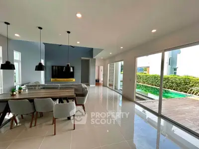 Spacious modern living room with pool view and elegant dining area