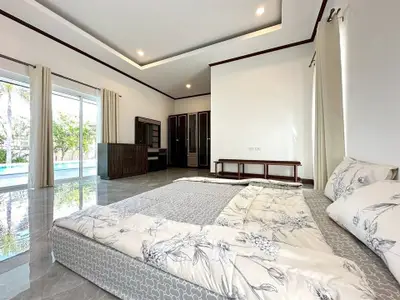 Spacious bedroom with pool view and elegant decor in modern home