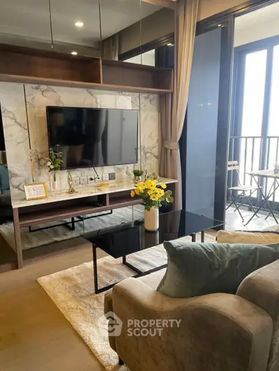 Modern living room with stylish decor, large TV, and balcony access in a luxurious apartment.