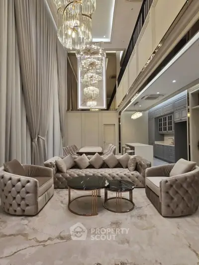 Luxurious double-height living room with elegant chandeliers and plush seating