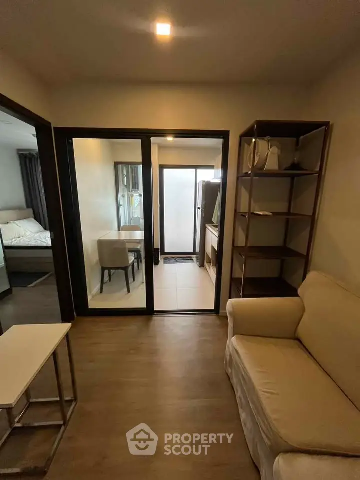 Cozy living room with modern furniture and open view to adjacent rooms, perfect for urban living.