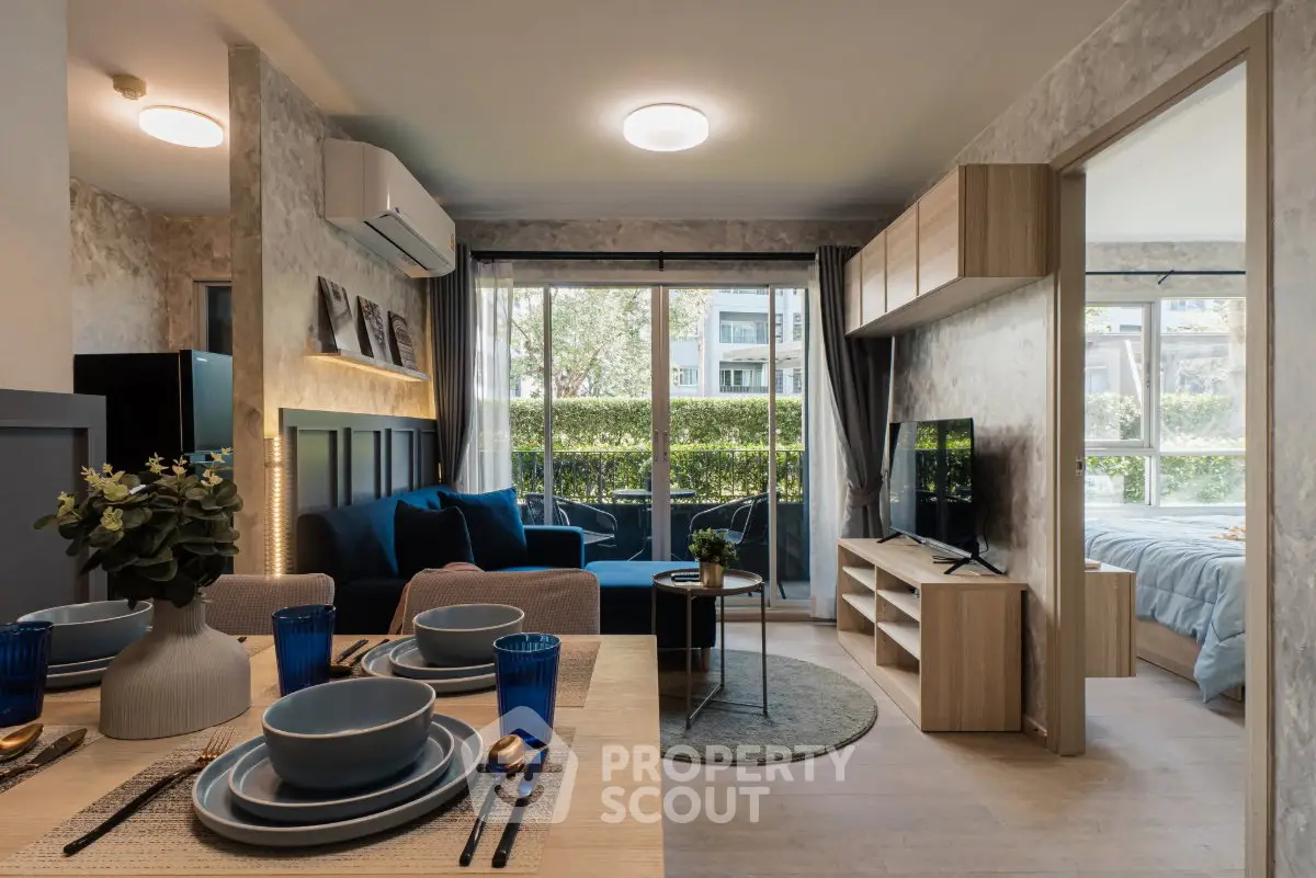 Modern open-plan living room with dining area and large windows overlooking greenery.