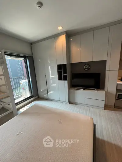 Modern bedroom with built-in storage and balcony access in urban apartment
