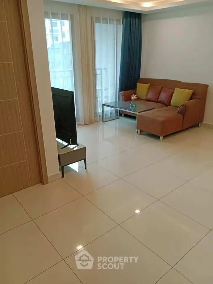 Spacious living room with modern sofa and large windows in a bright apartment.