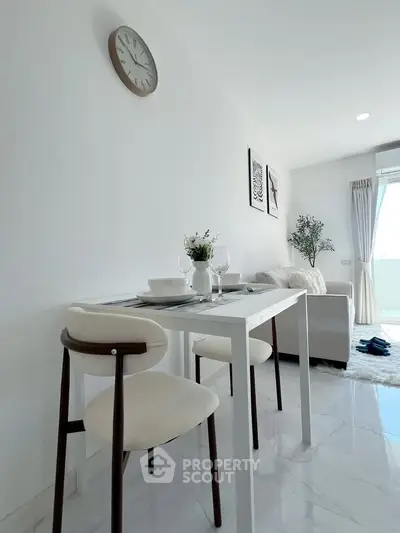 Modern living room with dining area, white decor, and natural light