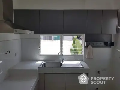 Modern kitchen with sleek cabinetry and stainless steel sink, perfect for culinary enthusiasts.