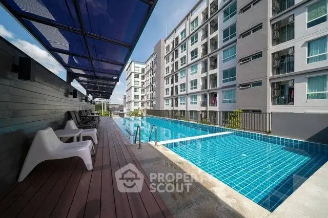 Modern apartment complex with a sleek outdoor pool and stylish seating area.