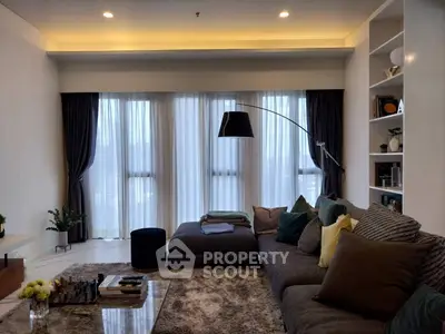 Elegant living room with plush seating and modern decor, featuring floor-to-ceiling windows and ambient lighting.