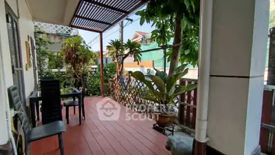 Charming balcony with lush greenery and cozy seating area for relaxation.