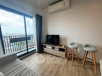 Modern living room with city view, featuring sleek furniture and large windows for natural light.