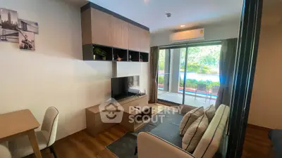 Modern living room with pool view, sleek furniture, and natural light.