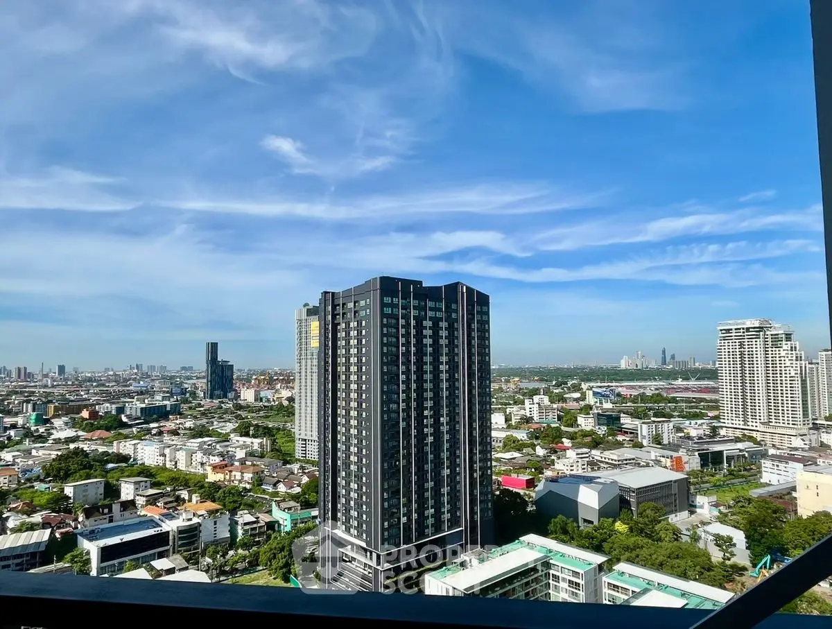 Stunning cityscape view from high-rise building balcony with clear blue sky.