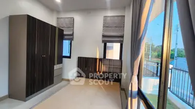 Spacious bedroom with large windows and modern wardrobe, offering ample natural light and serene views.