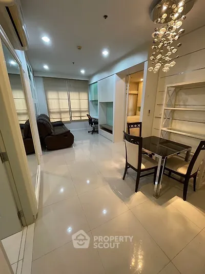 Modern apartment interior with open living and dining area, featuring stylish lighting and contemporary furniture.