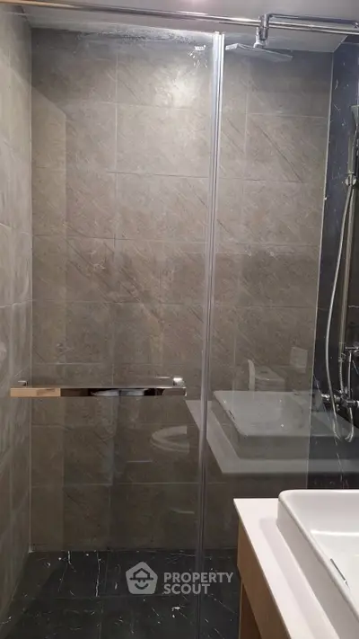 Modern bathroom with glass shower enclosure and sleek fixtures.