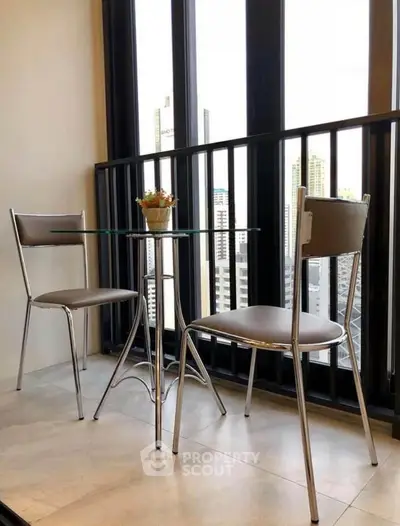 Chic balcony with modern chairs and table offering stunning city views.