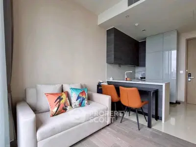 Modern living room with cozy sofa and stylish kitchen in open layout apartment.