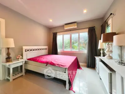 Spacious bedroom with elegant decor and large window for natural light