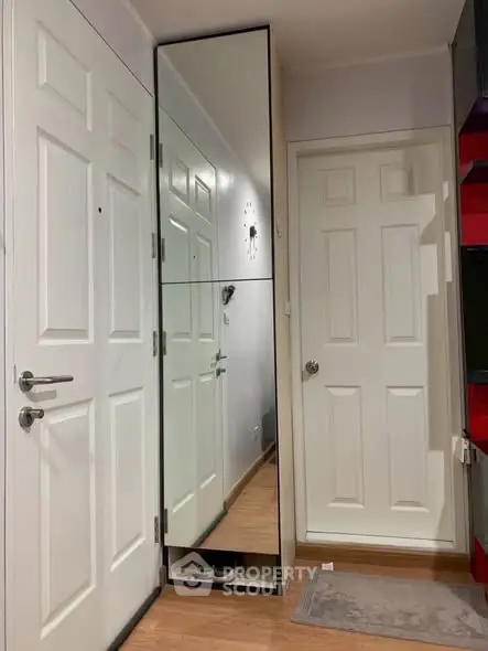 Modern apartment entryway with mirrored closet and stylish decor