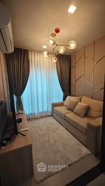Cozy living room with modern decor, plush sofa, and elegant lighting in a stylish apartment.